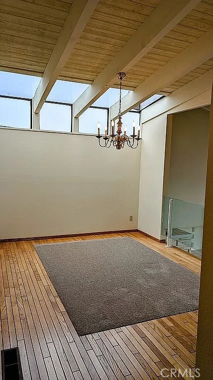 interior space with hardwood / wood-style flooring, beamed ceiling, wood ceiling, and an inviting chandelier