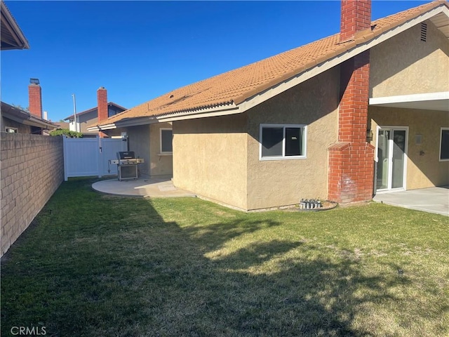 back of property with a yard and a patio area