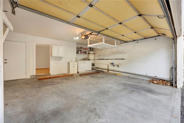 garage featuring separate washer and dryer and a garage door opener