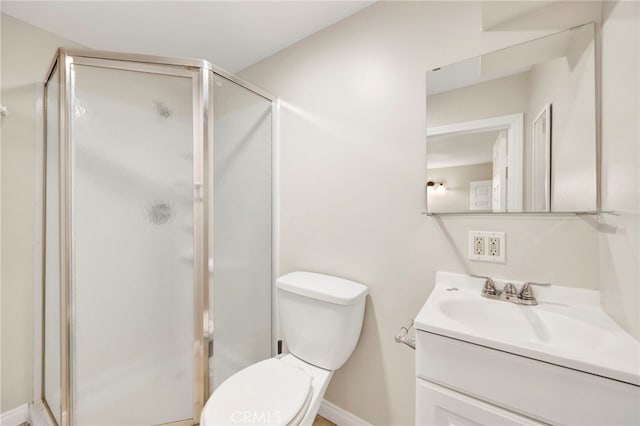 bathroom featuring vanity, toilet, and a shower with shower door