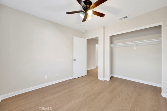 unfurnished bedroom featuring ceiling fan, light hardwood / wood-style floors, and a closet