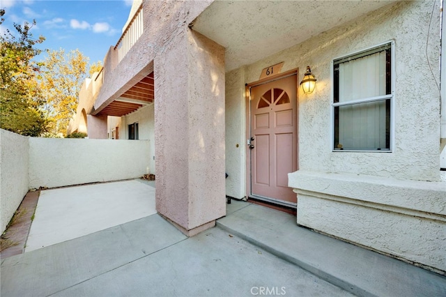 view of exterior entry with a patio area