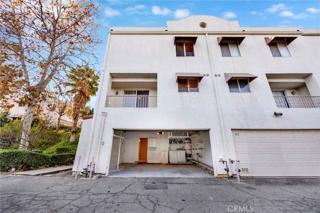 back of property featuring a balcony and a garage