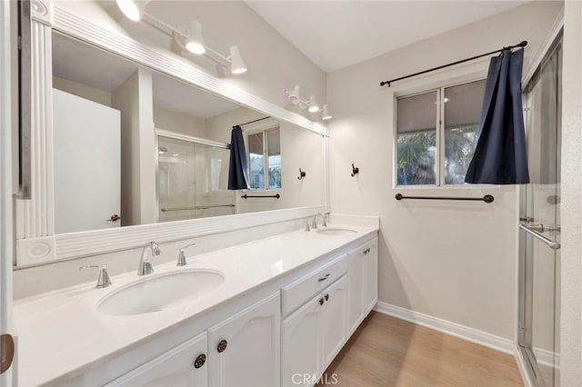 bathroom featuring vanity, an enclosed shower, and wood-type flooring