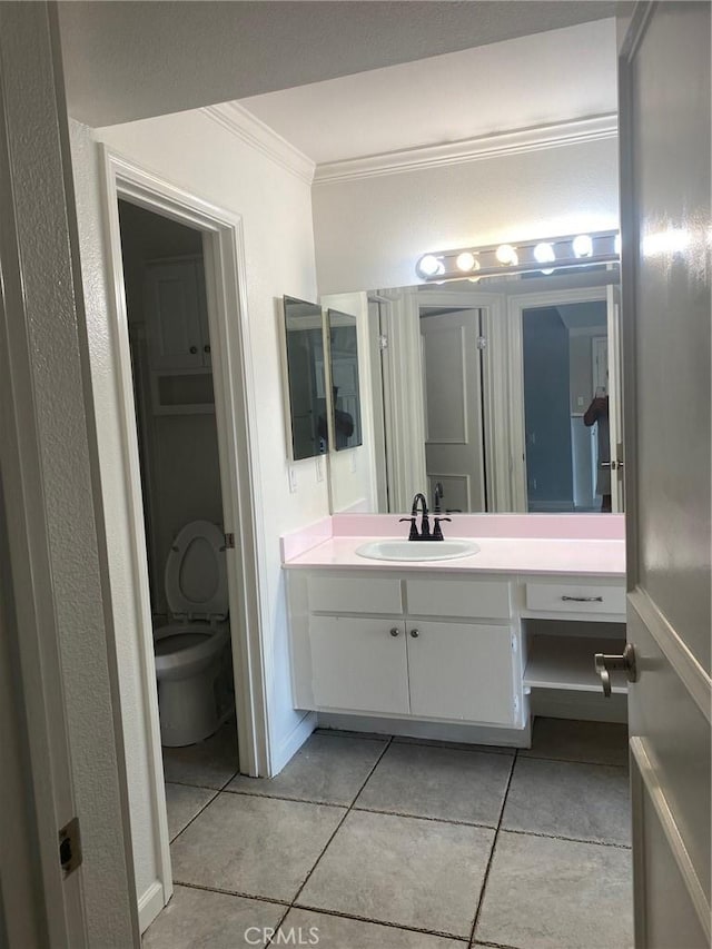 bathroom featuring tile patterned floors, toilet, vanity, and ornamental molding