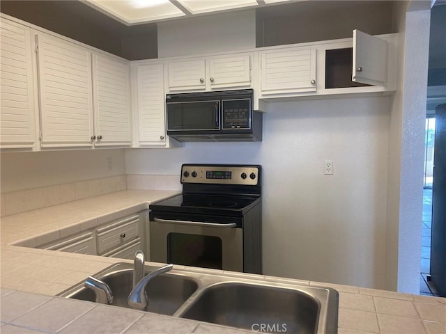 kitchen featuring white cabinets, tile countertops, and stainless steel electric range