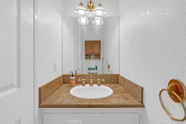 bathroom with vanity and an inviting chandelier