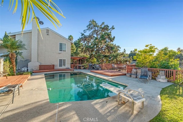 view of pool featuring a diving board and a wooden deck