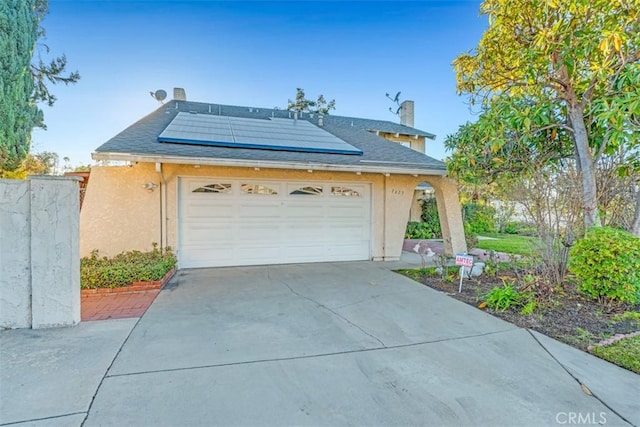 view of front of house featuring solar panels and a garage