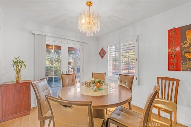 dining space featuring a notable chandelier, light hardwood / wood-style floors, and crown molding