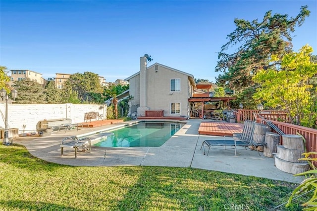 view of swimming pool featuring a yard, a patio, and a wooden deck