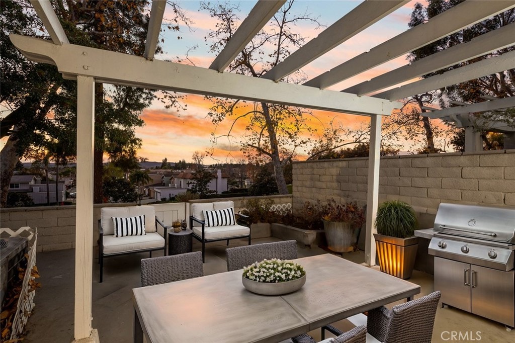 patio terrace at dusk with outdoor lounge area and a grill