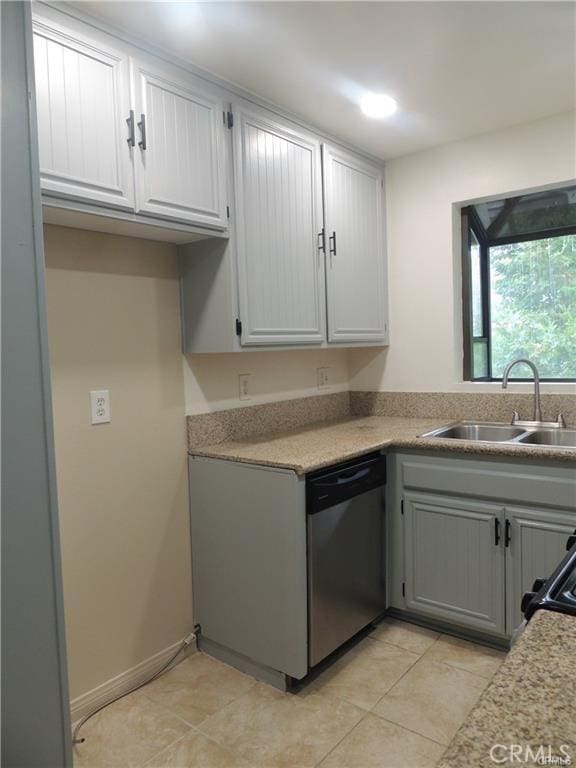 kitchen featuring stainless steel dishwasher, sink, and gray cabinetry