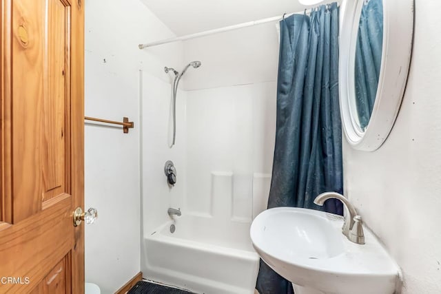 bathroom featuring shower / bath combo with shower curtain and sink