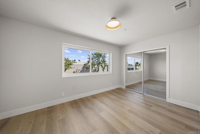 unfurnished bedroom with a closet and light wood-type flooring