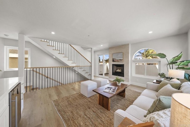 living room featuring a high end fireplace and light hardwood / wood-style floors