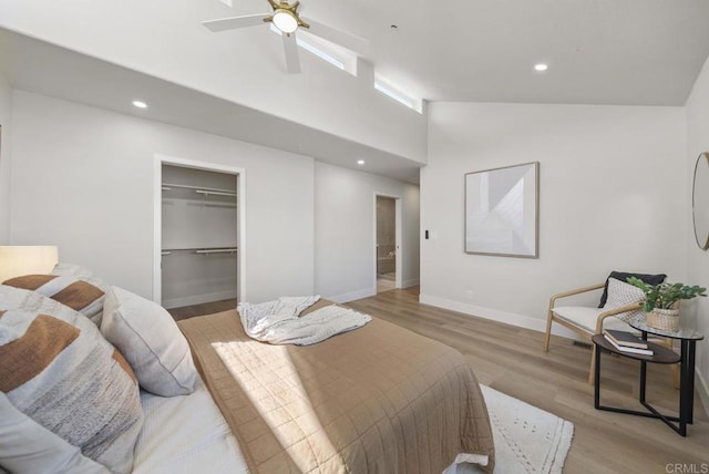 bedroom featuring ceiling fan, a closet, a towering ceiling, and light hardwood / wood-style floors