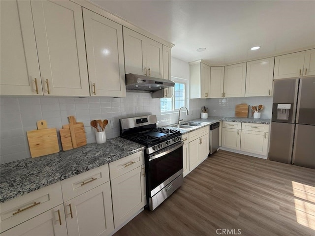 kitchen with sink, stainless steel appliances, dark hardwood / wood-style floors, and tasteful backsplash