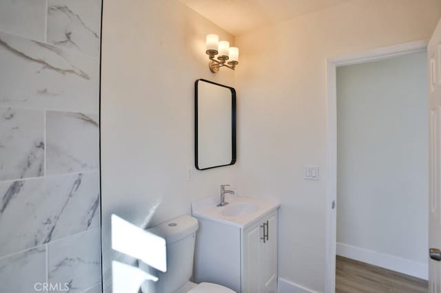 bathroom with hardwood / wood-style flooring, vanity, and toilet