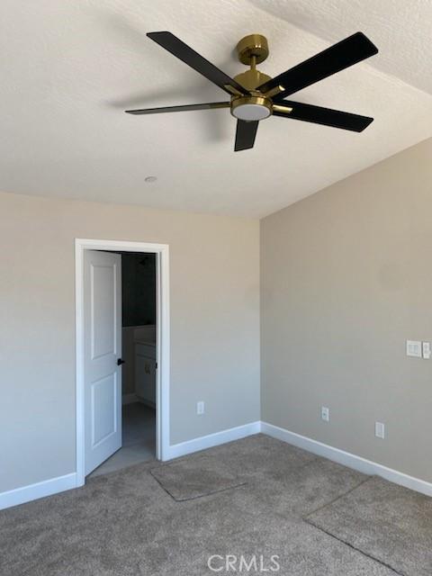 unfurnished room featuring carpet floors, a textured ceiling, and ceiling fan