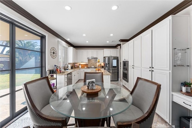 dining area featuring sink, ornamental molding, and plenty of natural light