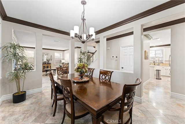 dining area featuring ornamental molding, sink, and a chandelier