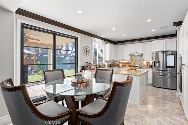 dining space featuring sink, ceiling fan, and crown molding