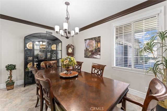 dining space featuring ornamental molding and a chandelier