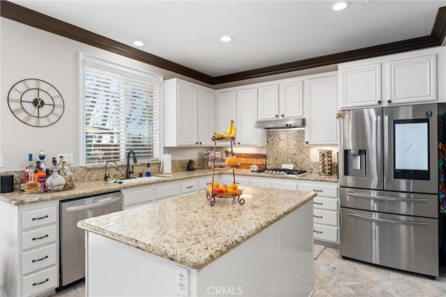 kitchen with sink, white cabinets, a center island, light stone counters, and appliances with stainless steel finishes