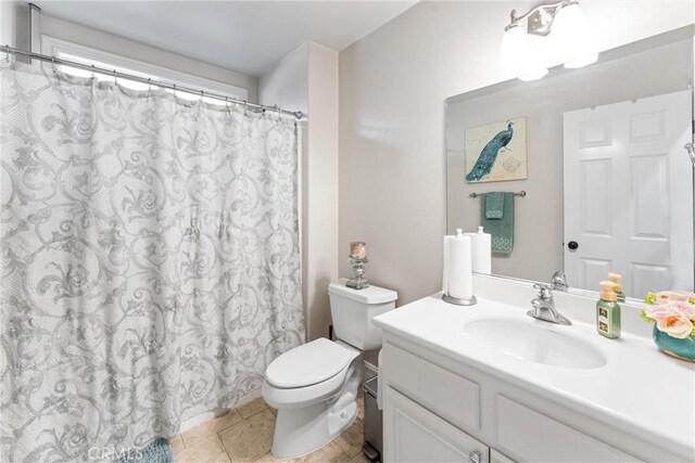 bathroom featuring toilet, vanity, and tile patterned flooring