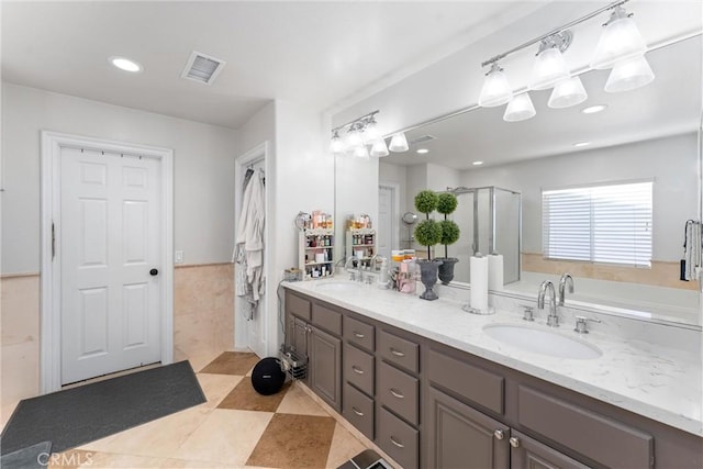 bathroom featuring tile walls, a shower with door, tile patterned floors, and vanity