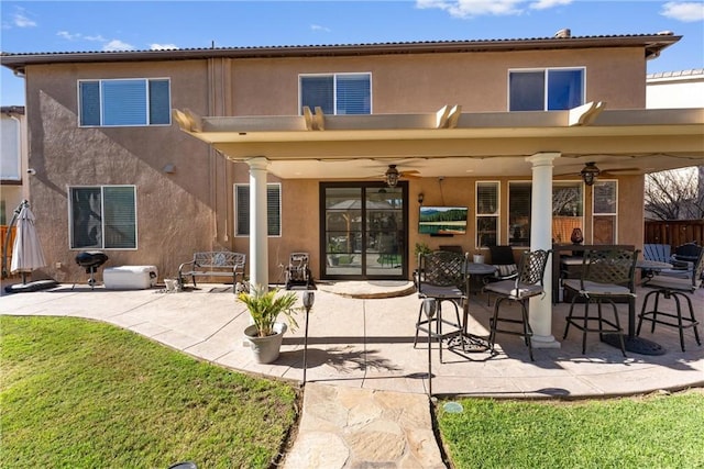 back of house featuring a yard, ceiling fan, and a patio