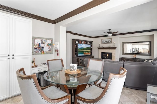 dining area with ceiling fan and crown molding