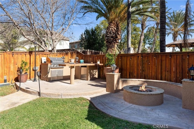 view of patio / terrace featuring an outdoor kitchen and an outdoor fire pit