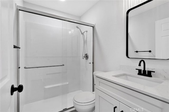 bathroom with toilet, an enclosed shower, and vanity