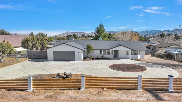 ranch-style home featuring a garage and a mountain view