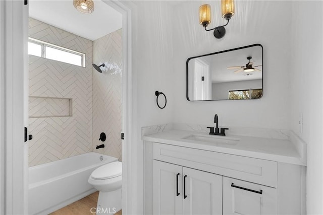 full bathroom featuring ceiling fan, tiled shower / bath, a healthy amount of sunlight, and vanity