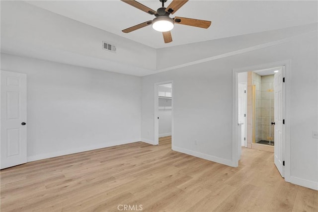 empty room with ceiling fan, light wood-type flooring, and vaulted ceiling