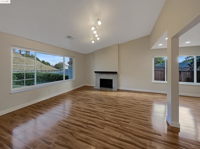 unfurnished living room featuring wood-type flooring and vaulted ceiling