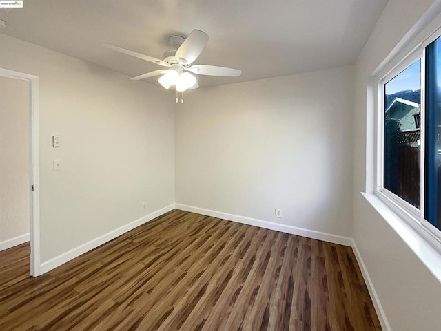 spare room featuring ceiling fan and dark wood-type flooring