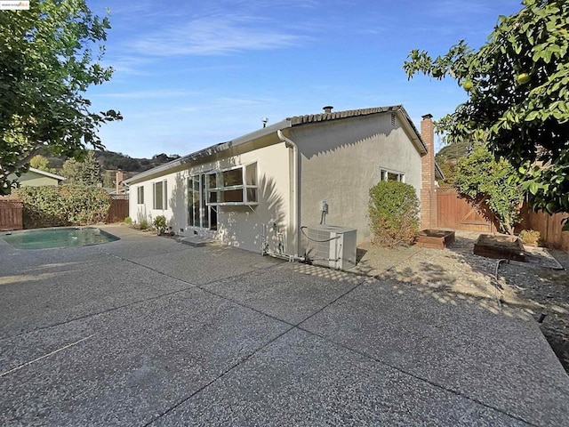 rear view of property with a patio area and central AC unit