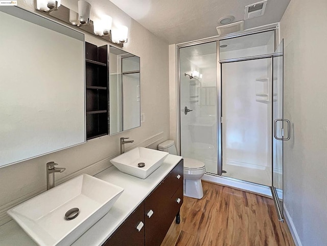 bathroom featuring hardwood / wood-style floors, toilet, an enclosed shower, and vanity