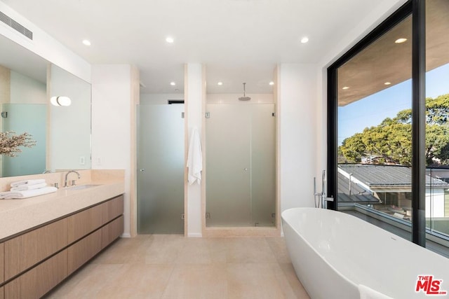 bathroom featuring tile patterned flooring, vanity, and independent shower and bath