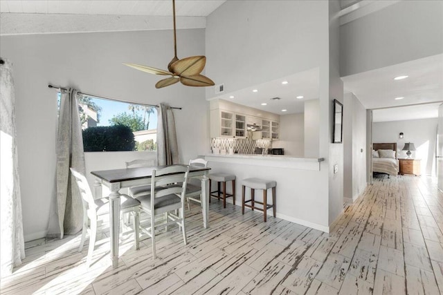 dining space featuring high vaulted ceiling and ceiling fan