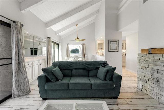 living room with high vaulted ceiling, ceiling fan, beamed ceiling, and light hardwood / wood-style flooring