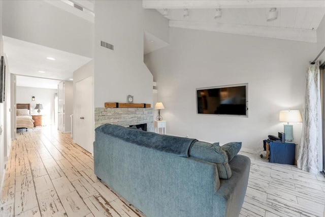 living room with a fireplace, high vaulted ceiling, and beam ceiling