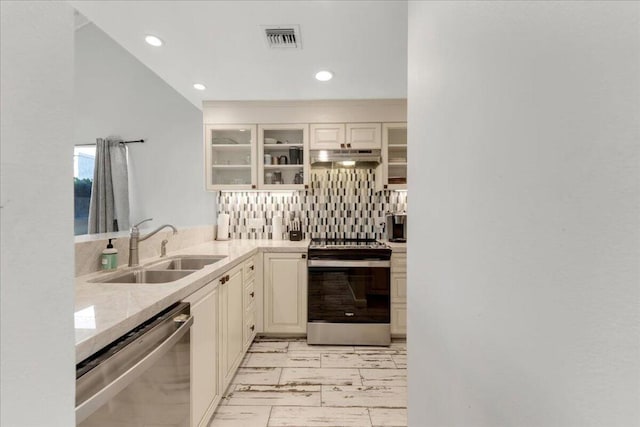 kitchen featuring appliances with stainless steel finishes, white cabinetry, decorative backsplash, and sink