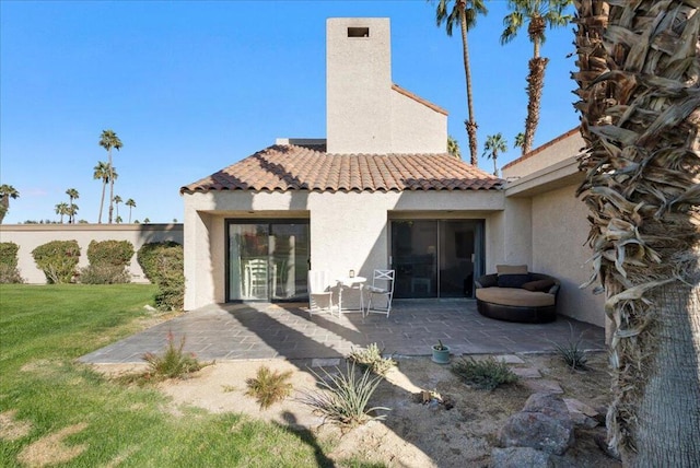 rear view of property with a lawn and a patio area