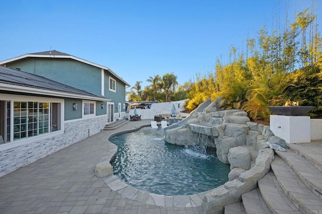 view of pool with pool water feature and a patio area