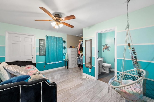 bedroom with ceiling fan, ensuite bathroom, and hardwood / wood-style flooring